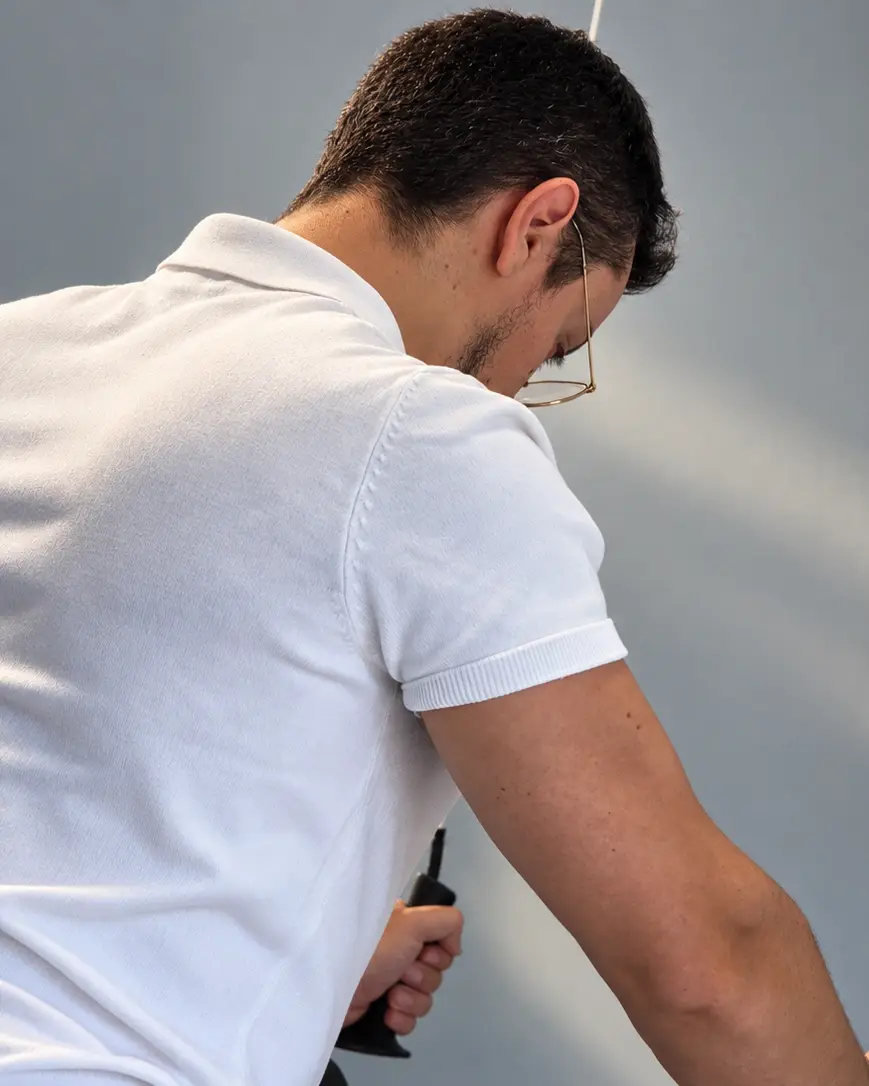 Luca Carloni alla cable machine del suo studio a Legnano, la mano sull’impugnatura