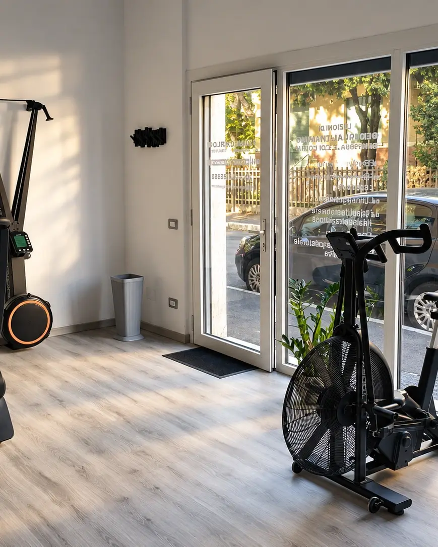 L’ingresso dello studio di Luca Carloni con la luce del mattino dalle vetrate, tapis roulant e air bike
