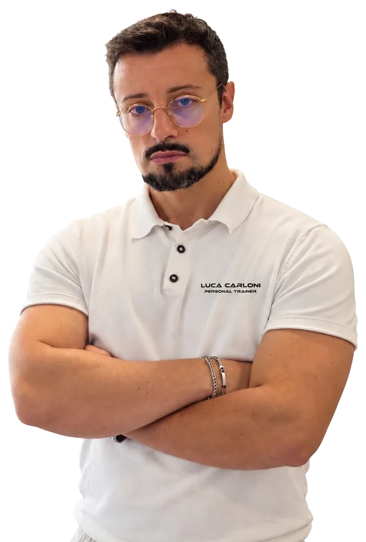 Luca Carloni, personal trainer a Legnano, a braccia conserte con la polo bianca dello studio, sguardo in camera